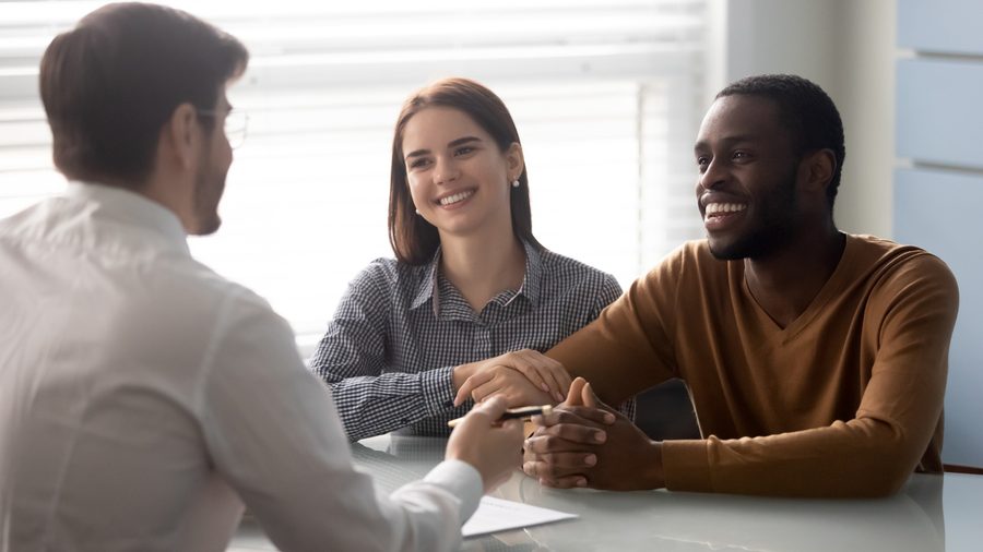 Smiling banker meeting with a couple at a table